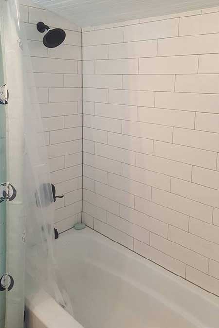 A bathtub and shower area with white tiles