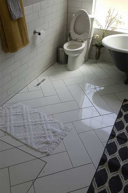 A bathroom with a toilet and black tub