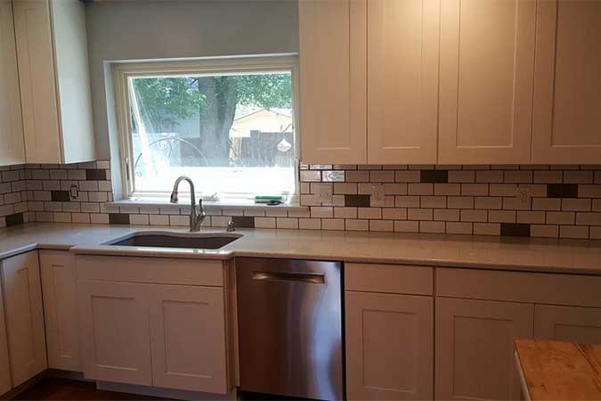 A kitchen with a big window over the sink